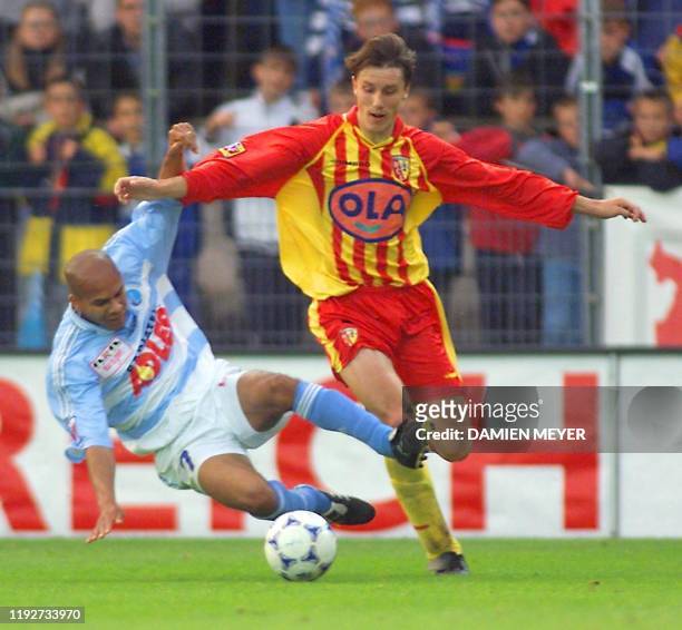 Le Strasbourgeois Stéphane Collet tente de tacler le Lensois Yoann Lachor , le 21 mai 1999 au stade de la Meinau à Strasbourg, lors du match...