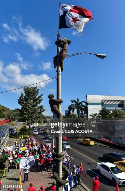 People stand in front of the martyrs monument during the commemorative act remembering the Martyrs Days in Panama City, on January 9, 2020. - Panama...