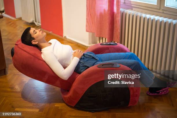 frau macht eine pause von der arbeit zu hause - massagestuhl stock-fotos und bilder