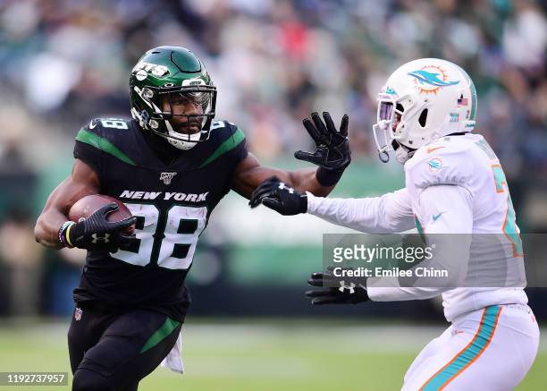 Ty Montgomery of the New York Jets stiff arms Eric Rowe of the Miami Dolphins during the second half of their game at MetLife Stadium on December 08,...