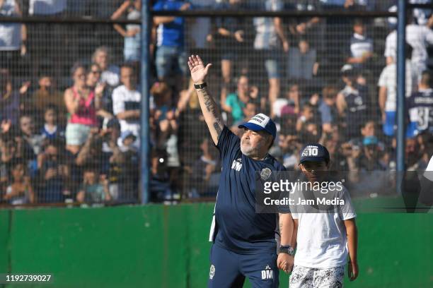 Diego Maradona head coach of Gimnasia waves the fans as walking with his grandson Benjamin Aguero prior a match between Gimnasia y Esgrima La Plata...