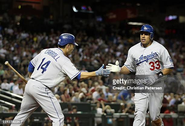 Juan Rivera of the Los Angeles Dodgers high-fives Jamey Carroll after Rivera scored a fourth inning run against the Arizona Diamondbacks during the...