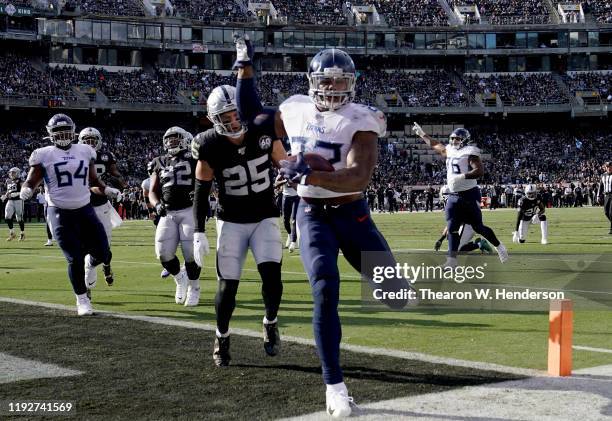 Derrick Henry of the Tennessee Titans carries the ball for a 12 yard touchdown run against the Oakland Raiders during the first half of an NFL...