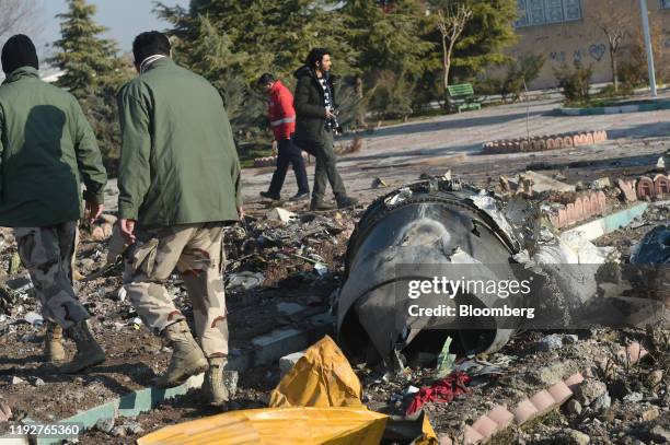 Rescue workers search the wreckage of a Boeing Co. 737-800 aircraft, operated by Ukraine International Airlines, which crashed shortly after takeoff...