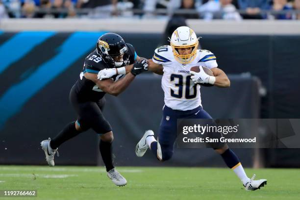 Austin Ekeler of the Los Angeles Chargers attempts to run past Marcus Gilchrist of the Jacksonville Jaguars during the game at TIAA Bank Field on...