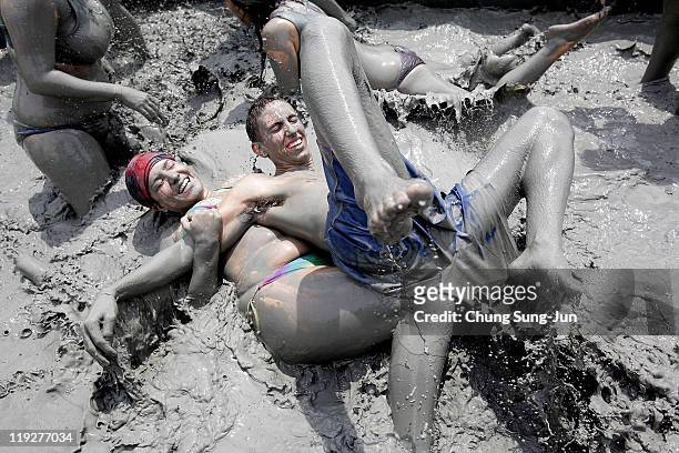 Festival goers wrestle in the mud during the 14th Annual Boryeong Mud Festival at Daecheon Beach on July 16, 2011 in Boryeong, South Korea. The mud,...