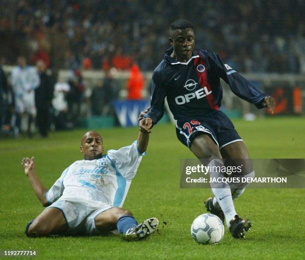 Le Marseillais Manuel Dos Santos essaie de tacler le Parisien Ogbeche , le 29 novembre 2001 au Parc des princes a Paris, lors de la rencontre...