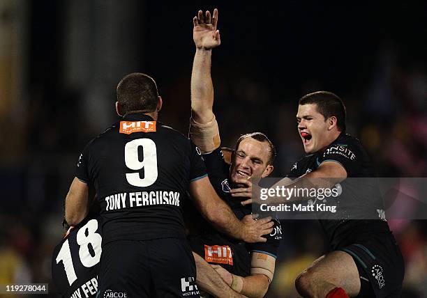 Luke Walsh of the Panthers celebrates with team mates after kicking the match winning field goal in extra time during the round 19 NRL match between...