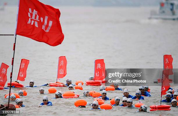 Participants swim in groups as they cross the Yangtze River during the 38th Wuhan International Yangtze River Crossing Festival on July 16, 2011 in...