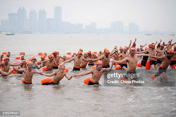 Participants cheer as they arrive at the endpoint of the 38th Wuhan International Yangtze River Crossing Festival on July 16, 2011 in Wuhan of Hubei...