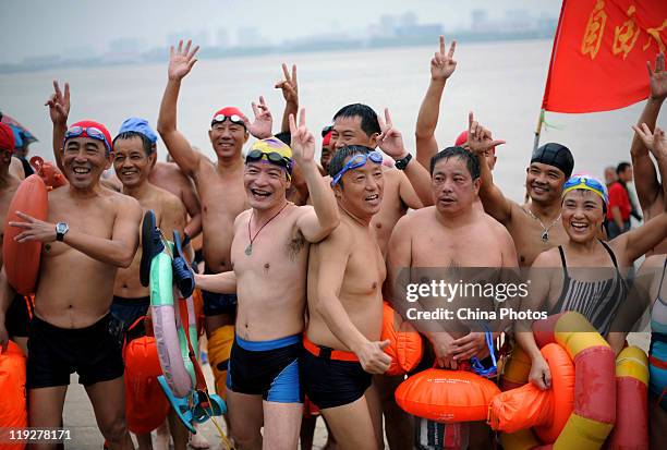 Participants cheer as they arrive at the endpoint of the 38th Wuhan International Yangtze River Crossing Festival on July 16, 2011 in Wuhan of Hubei...