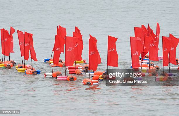 Participants swim in groups as they cross the Yangtze River during the 38th Wuhan International Yangtze River Crossing Festival on July 16, 2011 in...