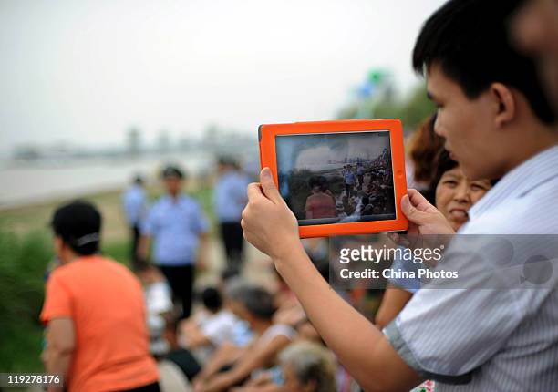 Man records swimmers crossing the Yangtze River with an iPad2 during the 38th Wuhan International Yangtze River Crossing Festival on July 16, 2011 in...