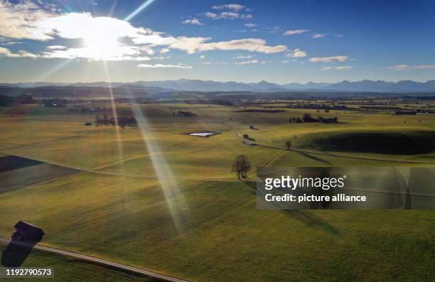 January 2020, Bavaria, Ruderatshofen: The meadows of the Allgäuer Alpenvorland lie in front of the panorama of the Alps in the sunshine . Photo:...