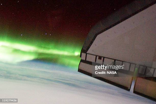 In this handout image provided by the National Aeronautics and Space Administration , the Southern Lights or Aurora Australis and the port side wing...