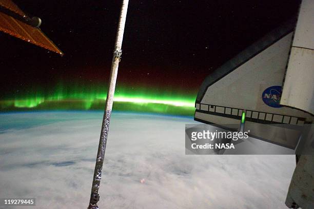 In this handout image provided by the National Aeronautics and Space Administration , the Southern Lights or Aurora Australis and the port side wing...