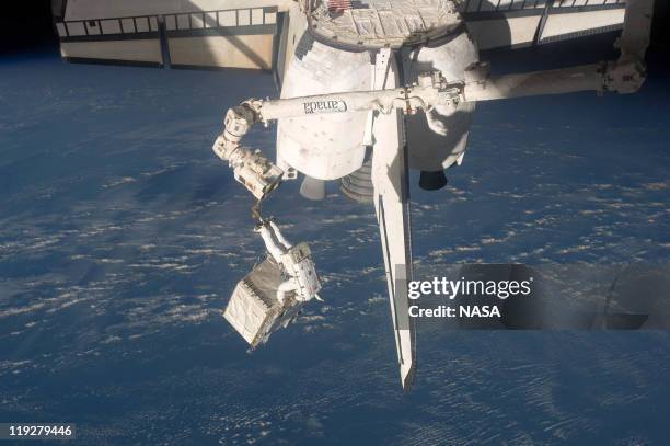 In this handout image provided by the National Aeronautics and Space Administration , NASA astronaut Ronald Garan attached to the robotic arm...