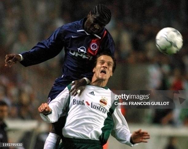 Le défenseur parisien Bernard Mendy effectue une tête au détriment du joueur viennois O. Lederer, le 18 octobre 2001 au Parc des Princes à Paris,...