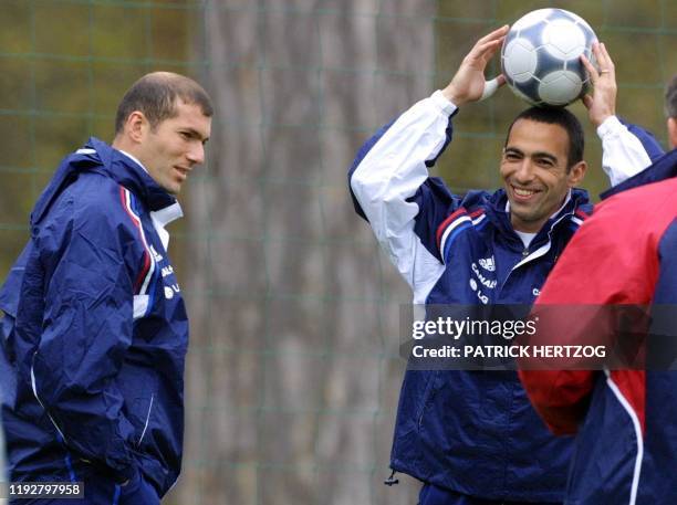 Les milieux de terrain français Zinedine Zidane et Youri Djorkaeff plaisantent, le 23 avril 2001, au Centre Technique du Football à Clairefontaine,...