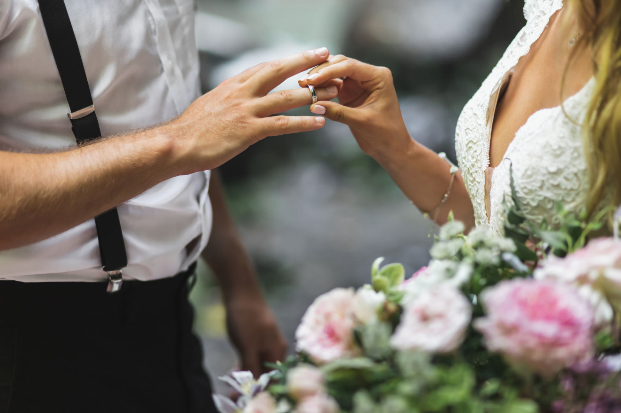 Bride putting wedding ring on groom's hand close up. Symbol of love and commitment. Wedding ceremony vows. Bride putting wedding ring on groom's hand close up. Symbol of love and commitment. Wedding ceremony vows.