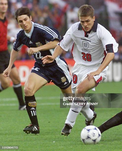 English forward Michael Owen runs for the ball next to Argentinian defender Javier Zanetti during the 1998 Soccer World Cup second round match...