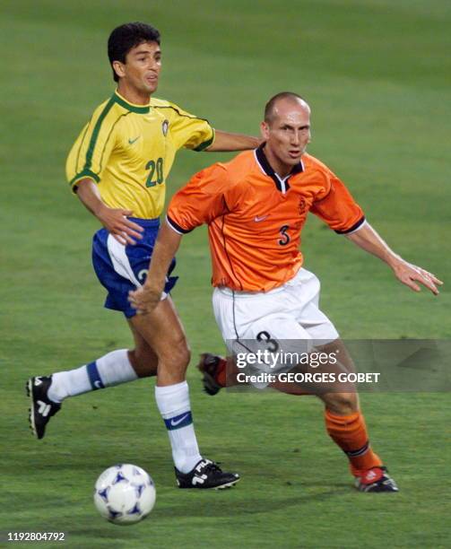 Brazilian forward Bebeto chases Dutch defender Jaap Stam 07 July during the 1998 Soccer World Cup semi-final match between Brazil and the Netherlands...