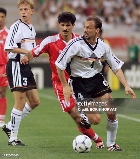 German defender Jurgen Kohler is challenged by Iranian forward Ali Daei as German midfielder Joerg Heinrich is looking on 25 June at the Stade de la...