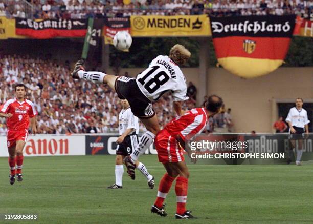 German captain Jurgen Klinsmann jumps over Iran's Mohammad Khakpour to kick the ball 25 June at the Stade de la Mosson in Montpellier, south of...