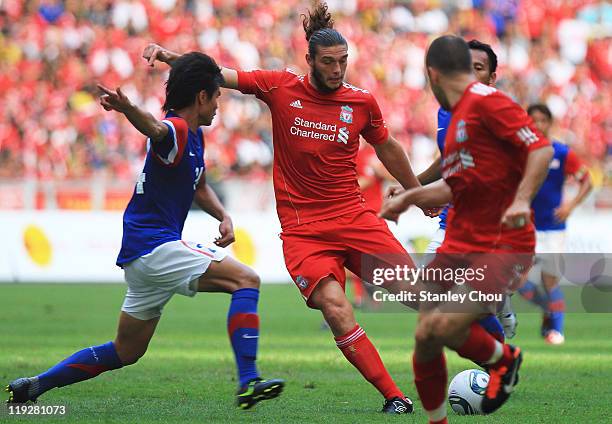Andy Carroll of Liverpool evades a tackle from Mahalli Jasuli of Malaysia during the pre-season friendly match between Malaysia and Liverpool at the...