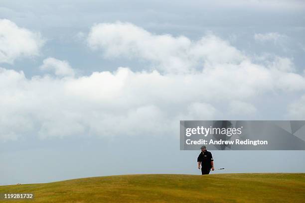 Darren Clarke of Northern Ireland walks up the 12th hole during the third round of The 140th Open Championship at Royal St George's on July 16, 2011...