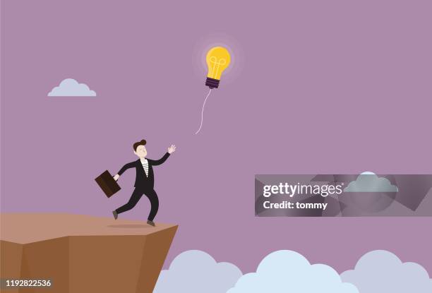 businessman trying to catch a light bulb on a cliff - intellectual property asia stock illustrations