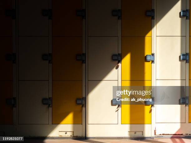 locker in the sunshine with an half in dark - objets perdus photos et images de collection