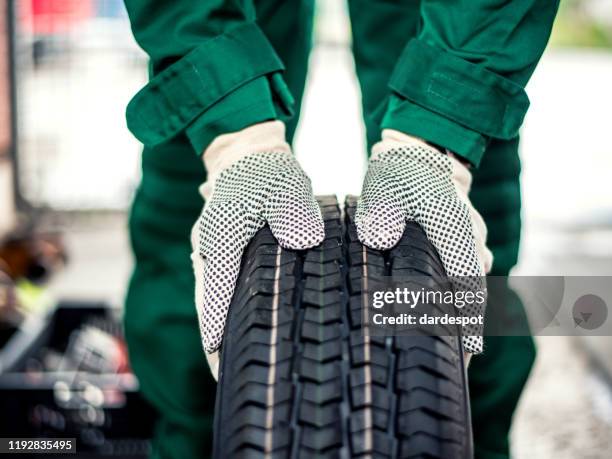 monteur handen duwen de band - car repairs stockfoto's en -beelden