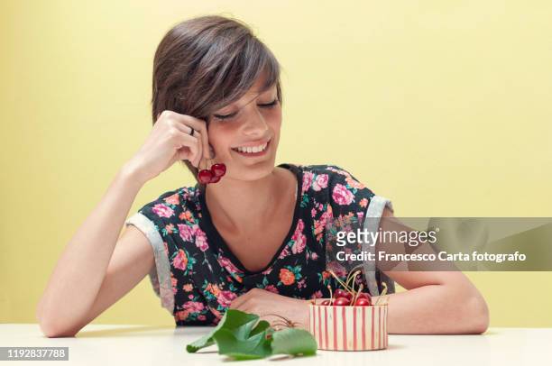 woman eating a cherry - kirschen tisch weiß stock-fotos und bilder