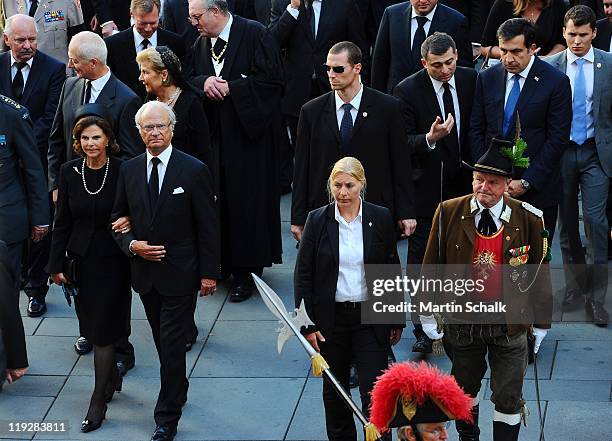 King Carl XVI Gustav of Sweden and Queen Silvia of Sweden walk in the cortege during the funeral ceremony for Otto von Habsburg seen in historic...