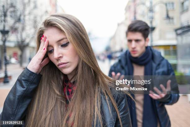 young couple breaking up on the street - breaking and exiting stock pictures, royalty-free photos & images