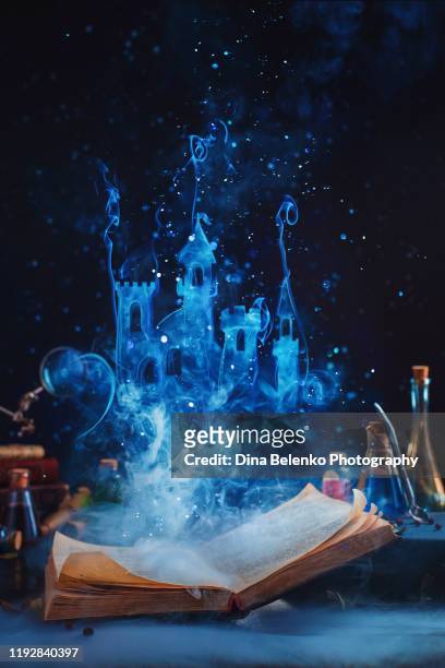 open book with a fantasy castle made of magical smoke. reading and imagination concept - wizard stock-fotos und bilder