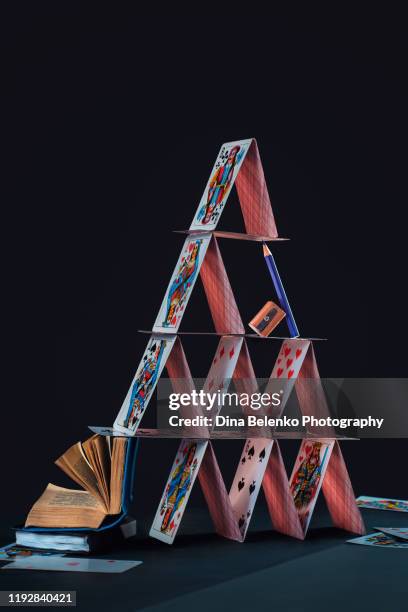 house of cards with an open book and a pencil. writing and poetry concept in creative still life - thinking of you card stock-fotos und bilder