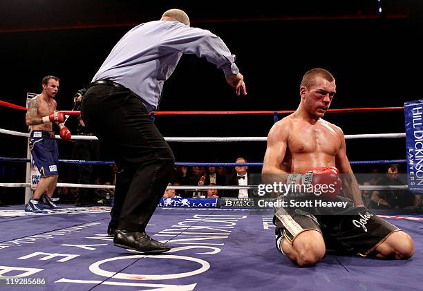 John Murray is knocked down by Kevin Mitchell during the vacant WBO Inter-Continental Lightweight Championship bout at Echo Arena on July 16, 2011 in...