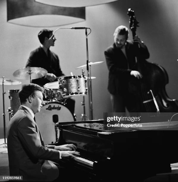 English jazz pianist Roy Budd performs with bassist Dave Holland and drummer Chris Karan on 'The Des O'Connor Show' for Associated Television in June...