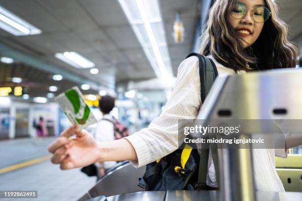teenage girl passing through fare gate at subway station - torniquete imagens e fotografias de stock