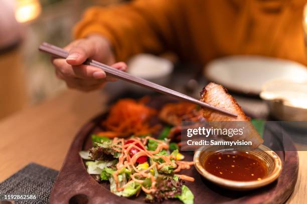asian woman tasting thai food in the restaurant - thailändische küche stock-fotos und bilder