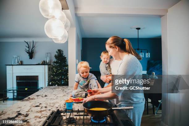 lesbian couple with their kids preparing dinner for the family - young family in kitchen stock pictures, royalty-free photos & images