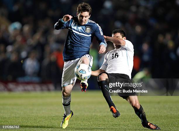 Lionel Messi of Argentina struggles for the ball with Maximiliano Pereira of Uruguay during a match as part of Copa America 2011 Quarter Final at...