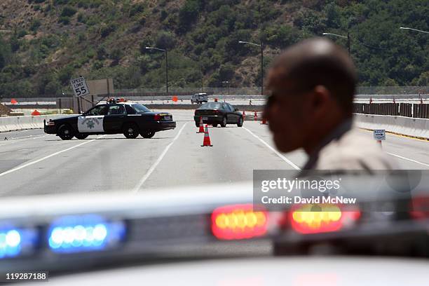 California Highway Patrol officers are seen on one of the busiest freeways in California, the 405, which stands vacant while workers demolish the...