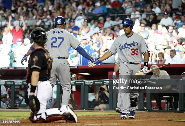 Juan Rivera of the Los Angeles Dodgers high-fives teammate Matt Kemp after Kemp hit a solo home run against the Arizona Diamondbacks during the...