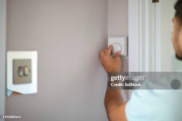 turning thermostat down - tuner stock pictures, royalty-free photos & images