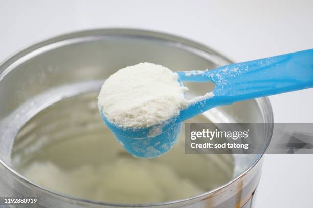 powder milk and blue spoon on light background close-up - baby powder fotografías e imágenes de stock