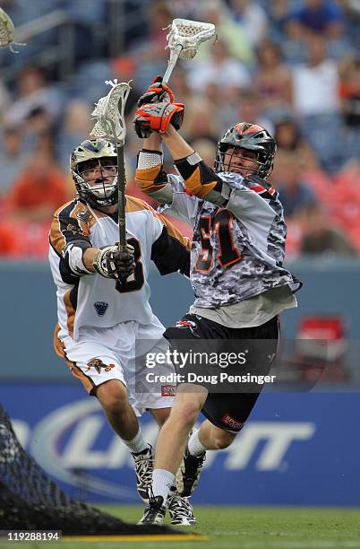 Peet Poillon of the Denver Outlaws controls the ball as Dan Groot of the Rochester Rattlers defends during their Major League Lacrosse game at...