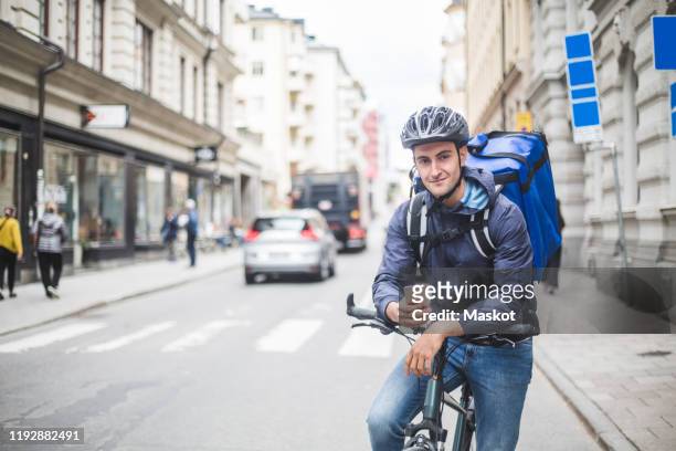 portrait of confident food delivery man with bicycle on street in city - part time worker stock pictures, royalty-free photos & images